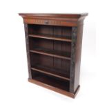 A Victorian oak open bookcase, the outswept pediment over three shelves flanked by vine carved