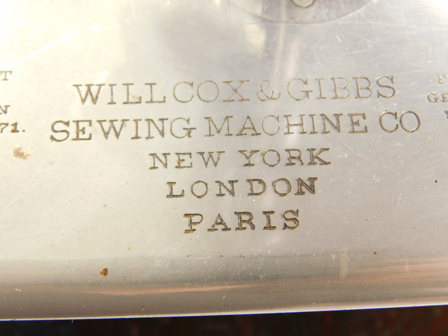 A late 19thC Wilcox & Gibbs sewing machine, gilt decorated black metal on a wooden base, together - Image 3 of 4