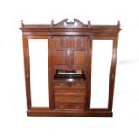 A Victorian mahogany compactum wardrobe, the outswept stepped pediment over a pair of doors