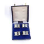 A set of four silver demi-lune napkin rings, initial engraved, cased, Birmingham 1992, 4.65oz.