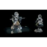 A Swarovski Crystal Christmas angel, boxed, and Girl with basket, boxed. (2)