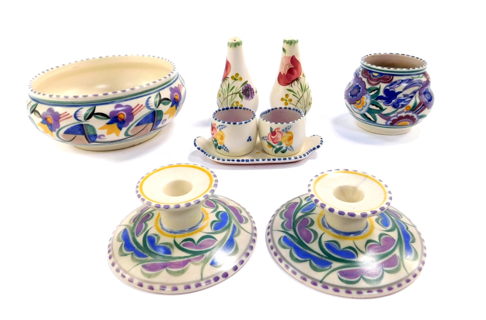 A group of Poole Pottery, traditionally painted with flowers, comprising a pair of candlesticks,