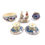 A group of Poole Pottery, traditionally painted with flowers, comprising a pair of candlesticks,