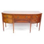 A George III mahogany bow front sideboard, with line inlay, and brass lion head and ring handles,