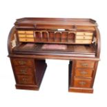 A Victorian mahogany roll top twin pedestal office desk, with a three sided galleried top, over a