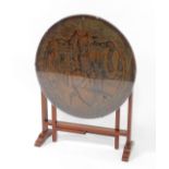 A Chinese hardwood tilt top gate leg occasional table, the circular top carved with figures, pagodas