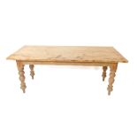 A pine kitchen table, the four plank top raised on turned supports, 77cm H, 194.5cm W, 77.5cm D.
