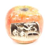 A Chinese 19thC ivory carving of an apple, the front open and showing figures and trees