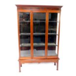 A Victorian mahogany display cabinet, the outswept pediment over a glazed front and sides, with