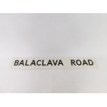 A painted metal sign for Balaclava Road, 102cm x 15cm.