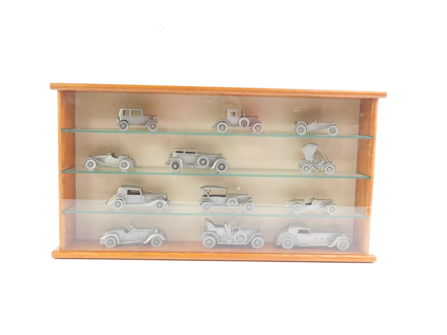 Twelve pewter models of vintage motor cars, in a wooden display case, glass fronted, case 53cm L.