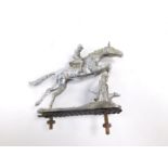 A chrome plated car mascot modelled as a huntsman and horse, jumping over a fence, 11cm H.