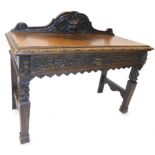 A Victorian carved oak side table, with a raised back above a single frieze drawer decorated with