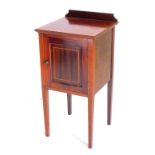 An Edwardian mahogany checker banded bedside cabinet, with single panel door, on square tapering