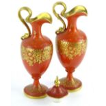 A pair of Royal Worcester porcelain ewers, each decorated in gilt with flowers, leaves etc., on a