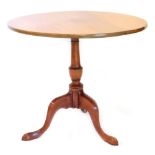 A mahogany occasional table in George III style, the circular tilt top on a turned column, tripod