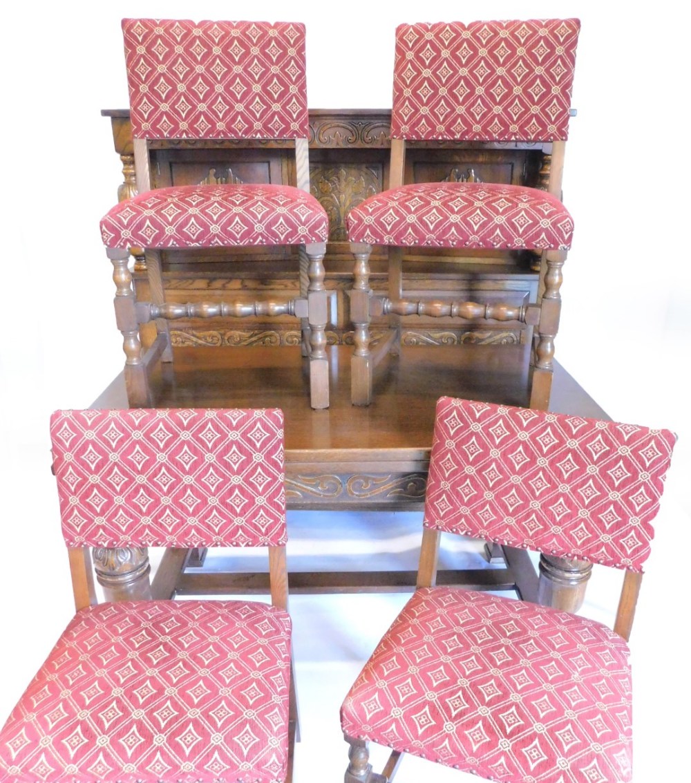 An oak dining room suite, comprising extending dining room table with two draw leaves on carved