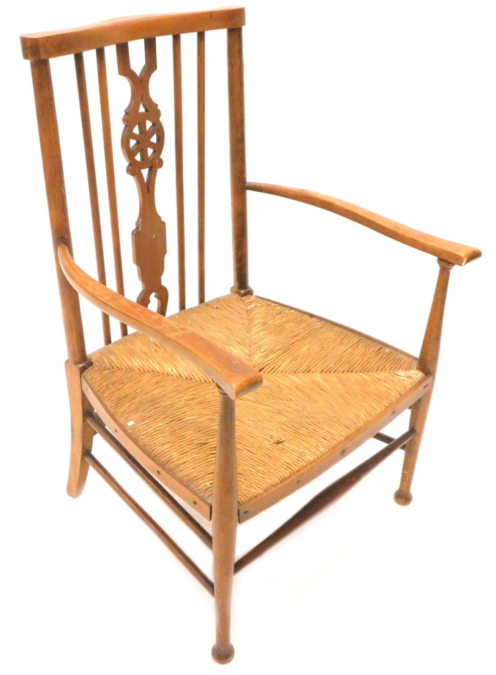 A late 19thC beech open armchair, in the Arts and Crafts style, with a pierced splat and rush seat.