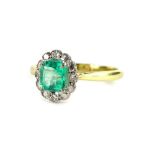 An 18ct gold emerald and diamond cluster ring, with square cut emerald in claw setting, surrounded