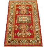 A Persian type rug, with three medallions on a red ground, multiple borders, 184cm x 124cm.