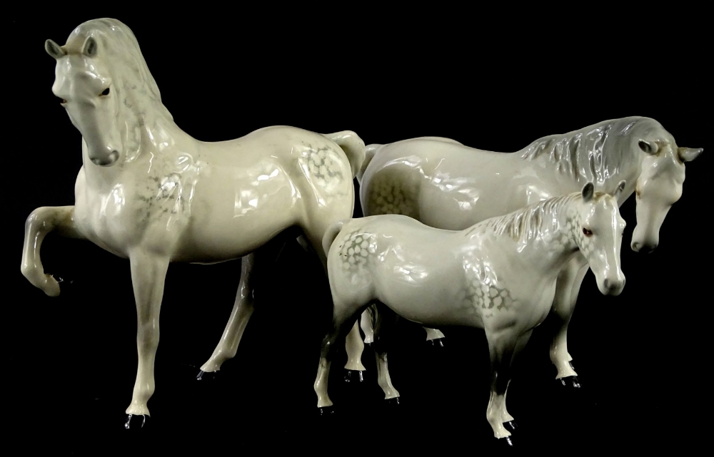 Three Beswick dappled grey horses, to include an example with a raised front hoof and a pony.