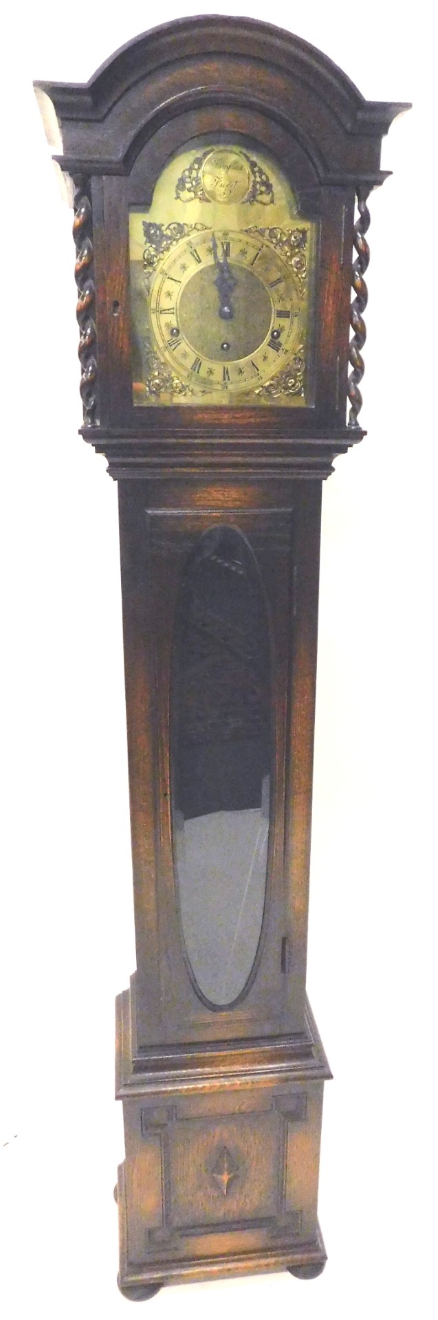 A grandmother clock in oak case, the arched brass dial signed Tempus Fugit above a single door