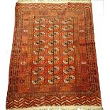 A Turkaman type rug, with a design of three rows of medallions on a red ground with multiple
