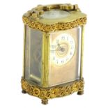 A late 19thC French carriage timepiece, the gilt brass case decorated with scrolls etc., the