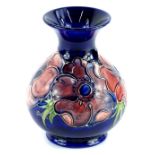 A Moorcroft pottery baluster shaped vase, decorated with a band of poppies on a navy blue ground,