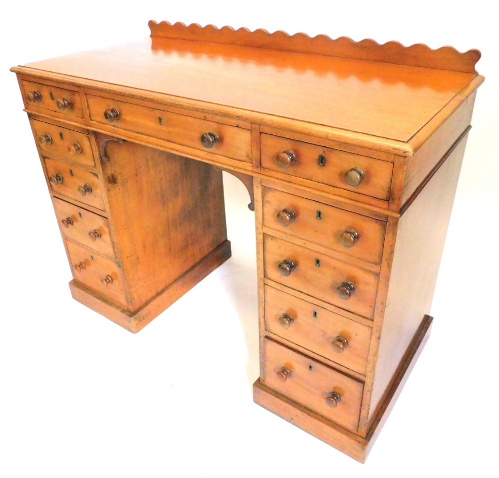 A Victorian mahogany dressing table, with a raised back, above an arrangement of eleven drawers, the