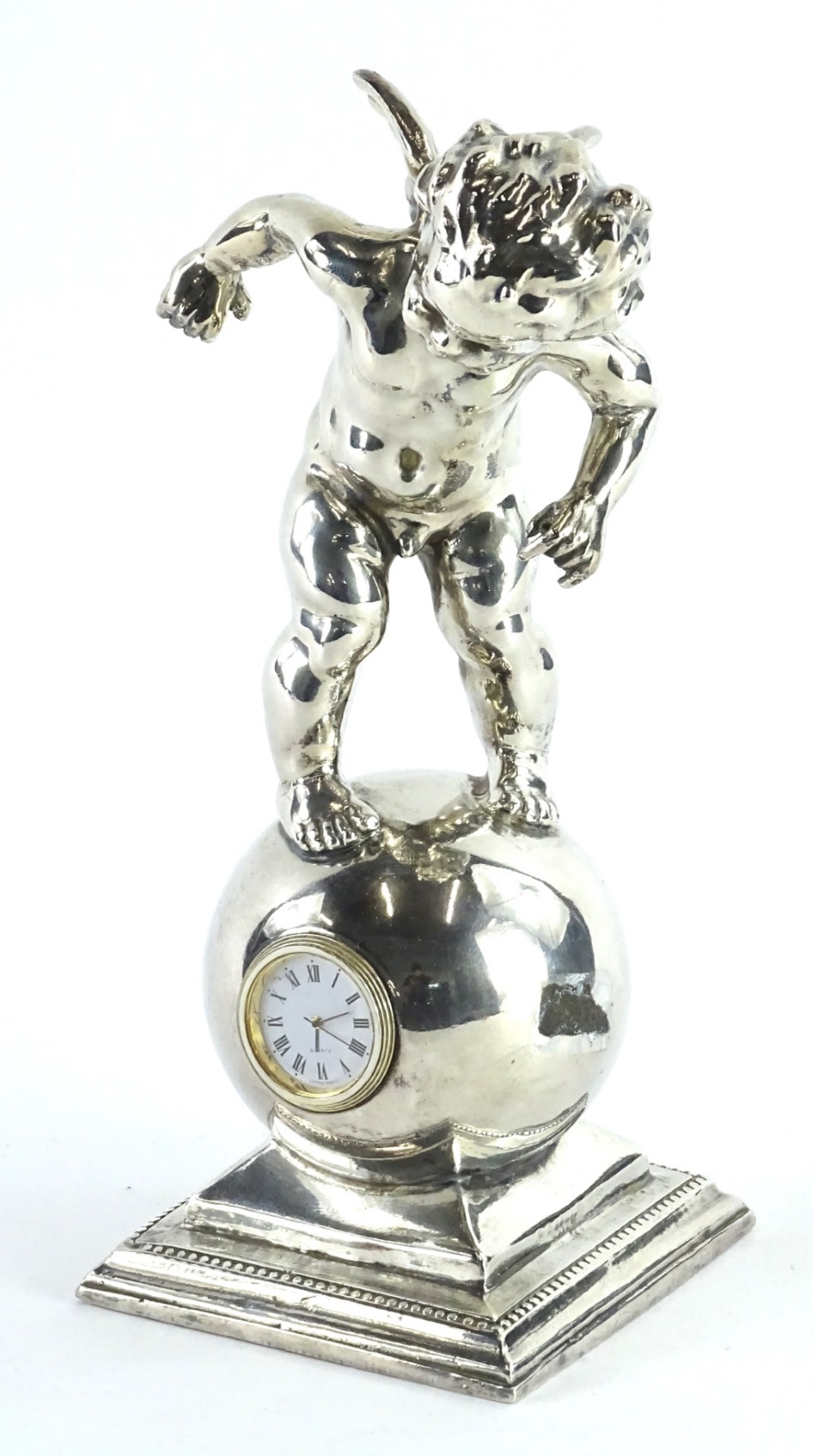 A silver coloured metal mantel clock, cast in the form of a putto on a globe, the movement stamped