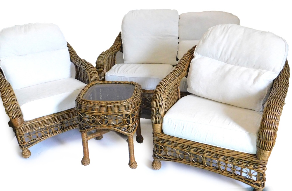 A conservatory three piece rattan suite, comprising two seater sofa, two armchairs, and a matching