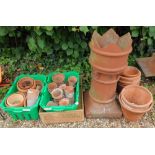 A terracotta chimney pot, with crenellated top, 78cm H and various terracotta pots.