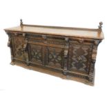 A large late Victorian oak sideboard, the top with a shallow raised back and a moulded edge above