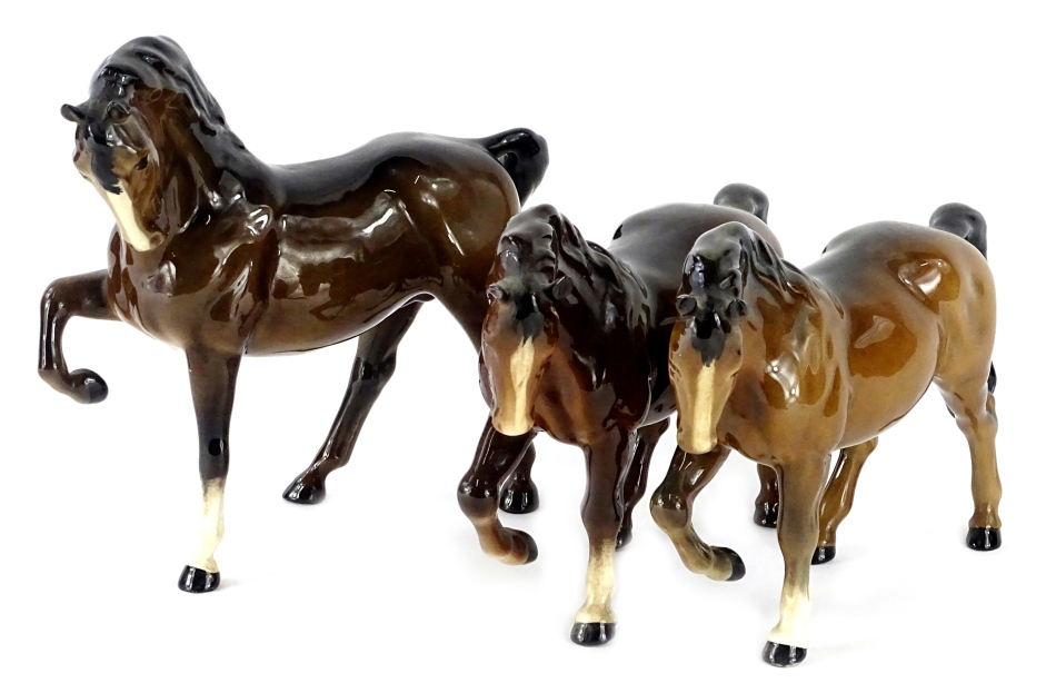 Three Beswick brown horses, each with foot raised.