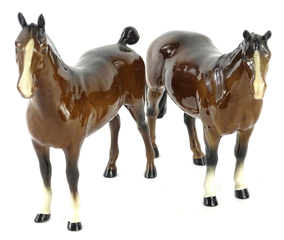 Two Beswick brown horses, each with white socks, one with cropped tail.