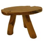 A rustic hardwood coffee table, the circular top made from a single slice from a trunk on three
