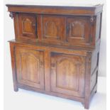 A 17thC oak deudarn, the raised back with three carved panel doors and drop finial's, the base