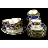 A Noritake porcelain part tea service, decorated with scrolls, leaves etc., in gilt within blue