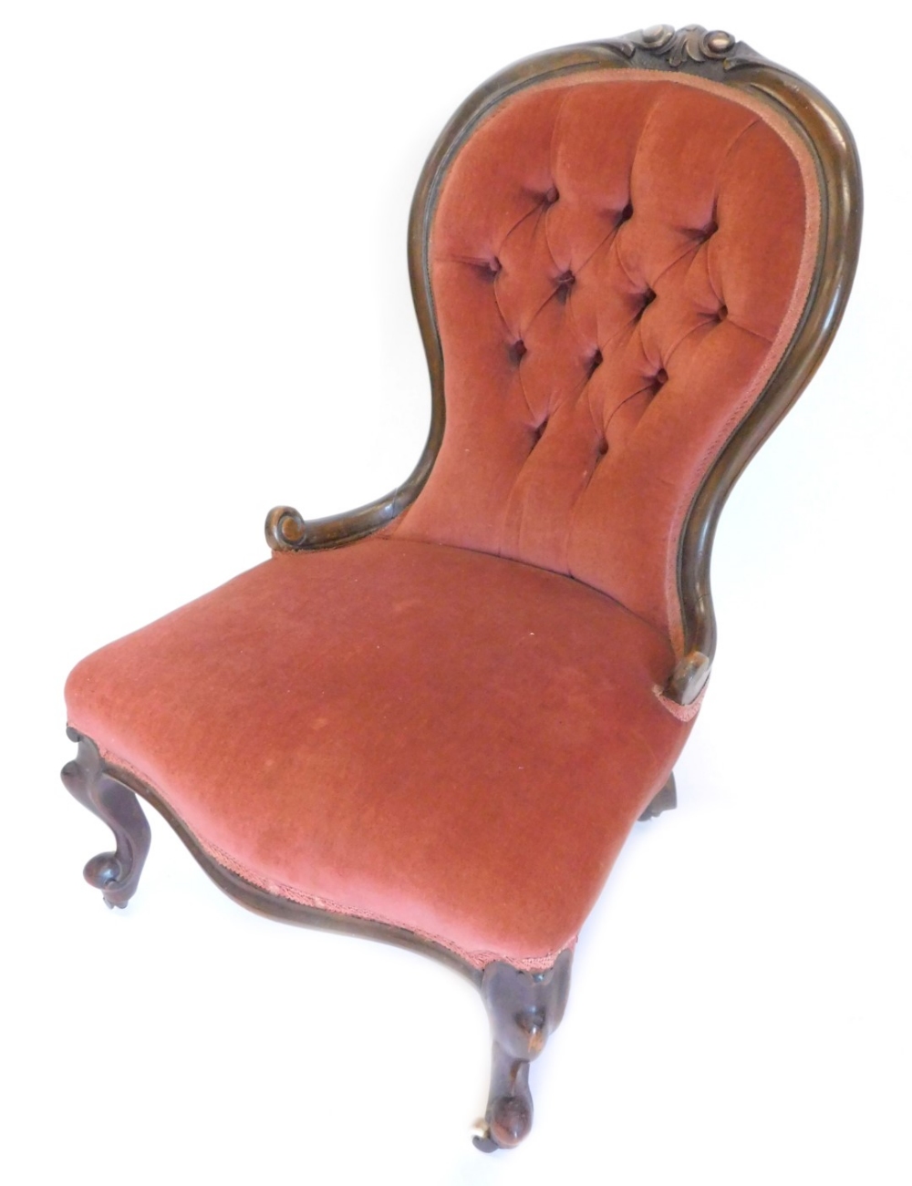 A Victorian walnut nursing chair, the button back, a padded seat on scroll carved legs with