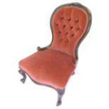A Victorian walnut nursing chair, the button back, a padded seat on scroll carved legs with
