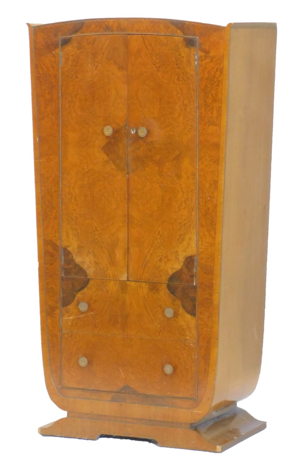 An Art Deco figured walnut small wardrobe, with two doors, above two drawers on a shaped base,