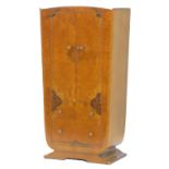 An Art Deco figured walnut small wardrobe, with two doors, above two drawers on a shaped base,