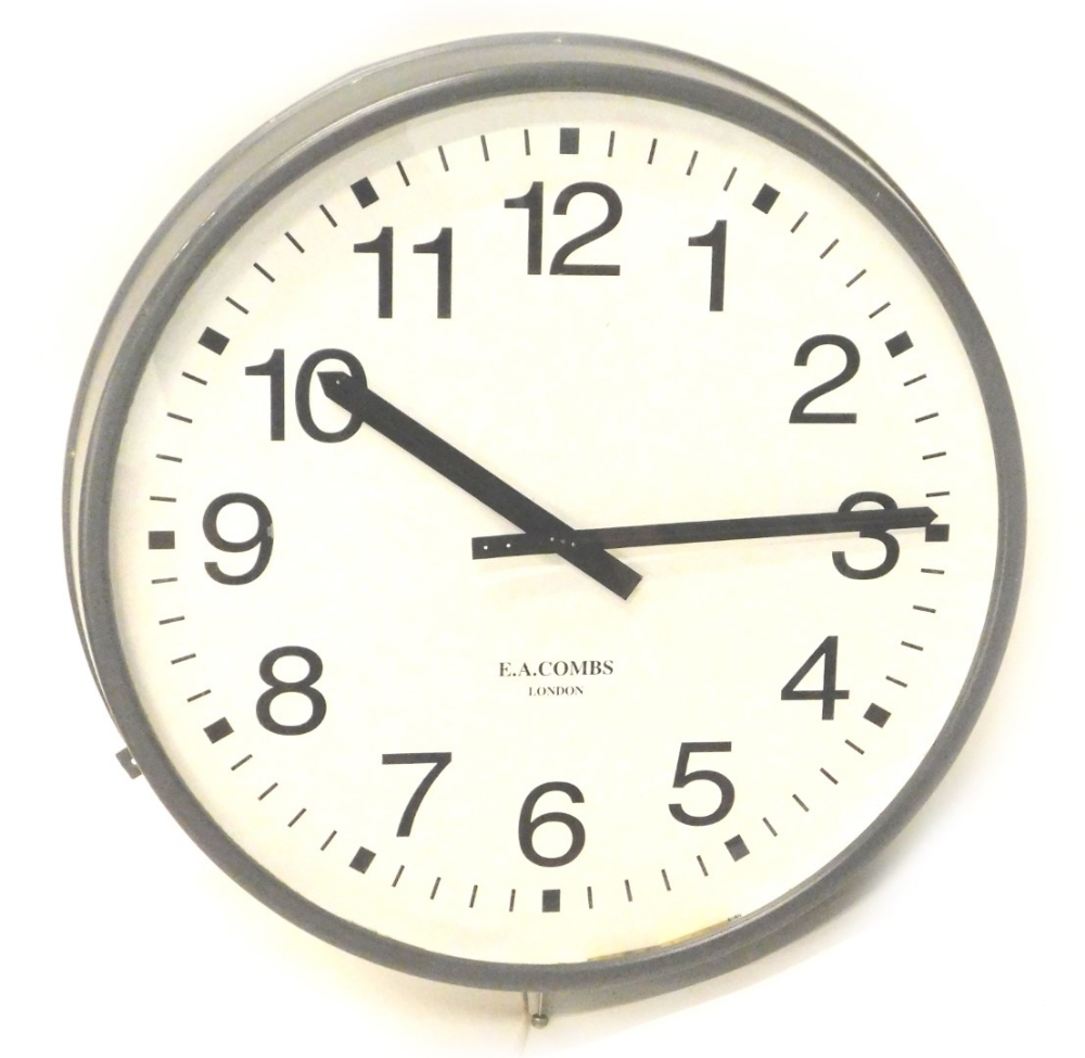 A large factory type clock, with grey painted frame, the dials bearing name E.A. Combs London,