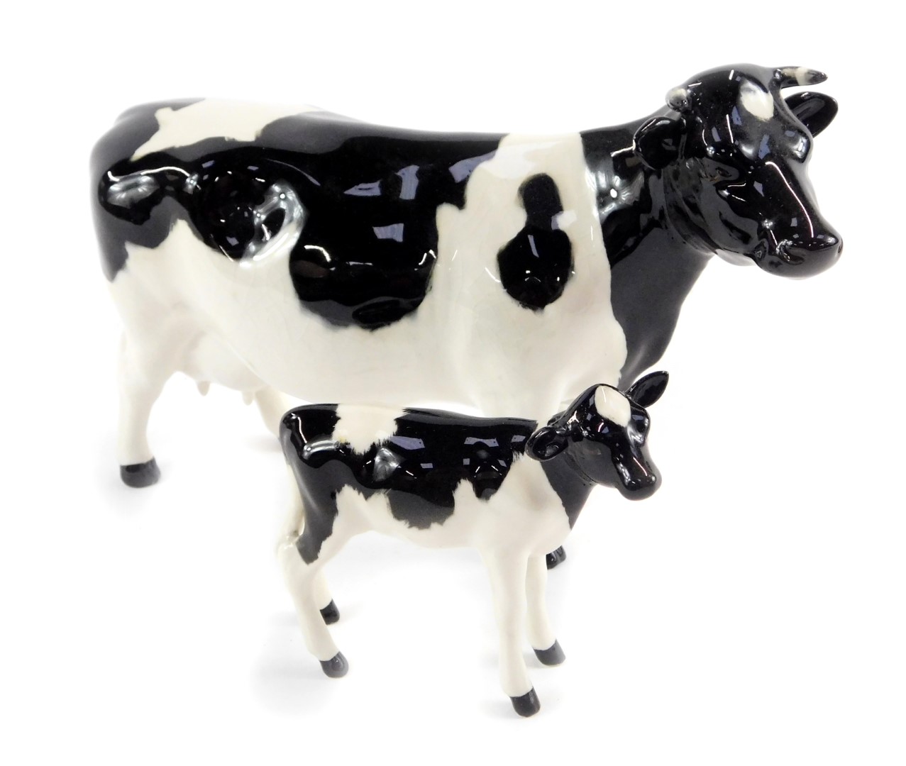 A Beswick figure modelled as a Friesian cow, 13cm H, together with a Friesian calf, 7.5cm, both
