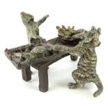 A small cold painted bronze group, depicting two cats preparing food, etc., at a table, bearing mark