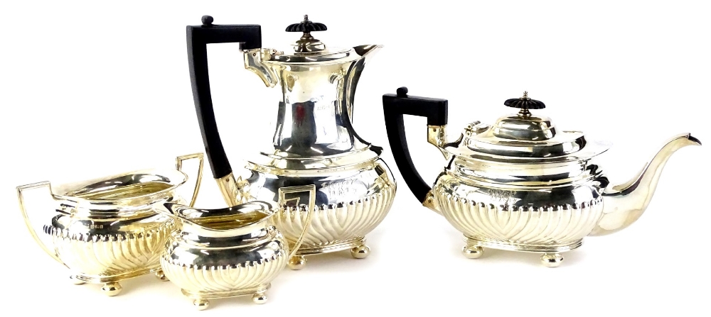 A George V silver four piece tea set, with part fluted body engraved with initials, the coffee pot
