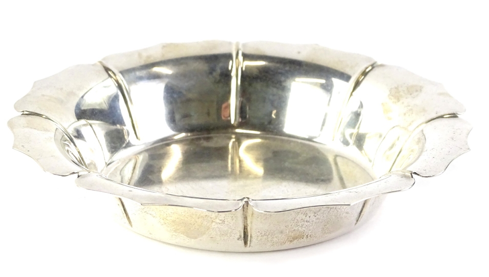 A sterling silver wine coaster, modelled in the form of a flowerhead, with shaped raised edge,