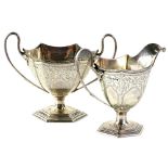 A George V silver hexagonal two handled sugar bowl, engraved with scrolls around various vacant