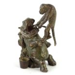 A cold painted bronze group, modelled in the form of a monkey extracting a tooth from a hippo, in